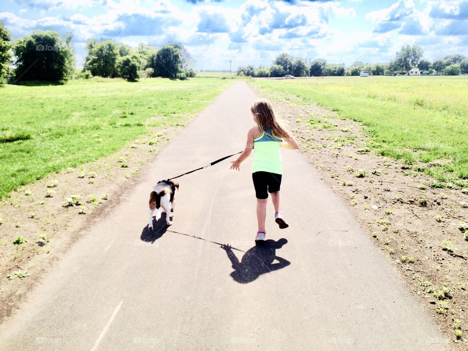 Sweet photo of little girl running on path with a dog on a beautiful sunny day!! 