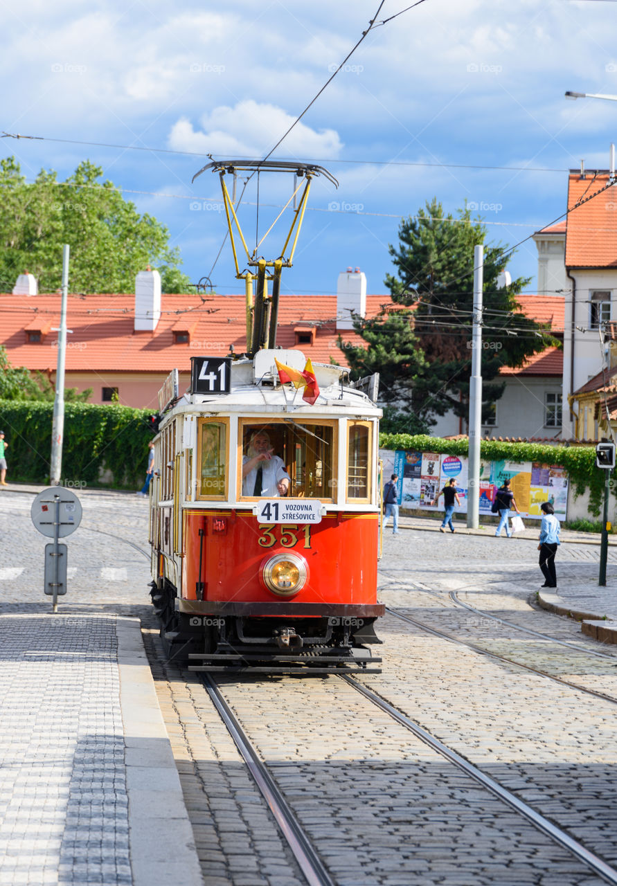 Prague, Czech Republic - July 1, 2017: Historical Prague museum tram line 41 and an old tram driver on a cobble stone street in Mala Strana district of Prague, Czech Republic on a sunny July afternoon