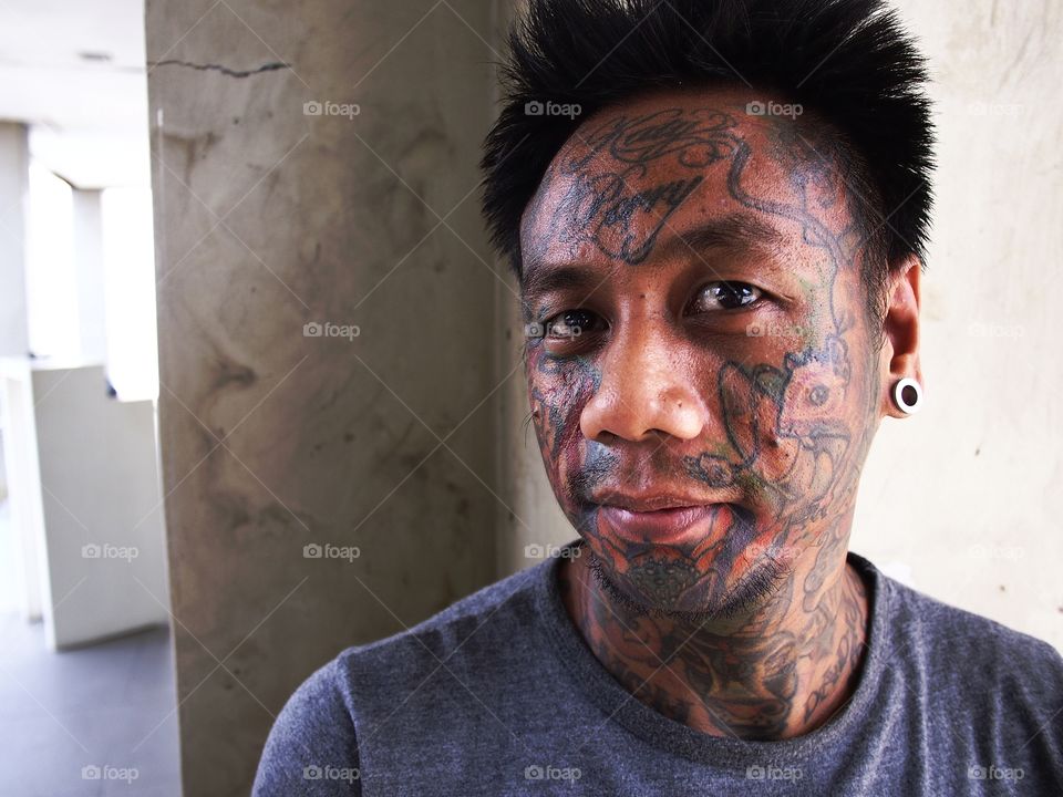 portrait of a man with facial tattoo