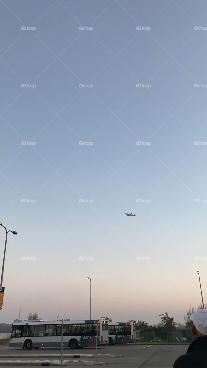 Busstop with an airplane in the sky
