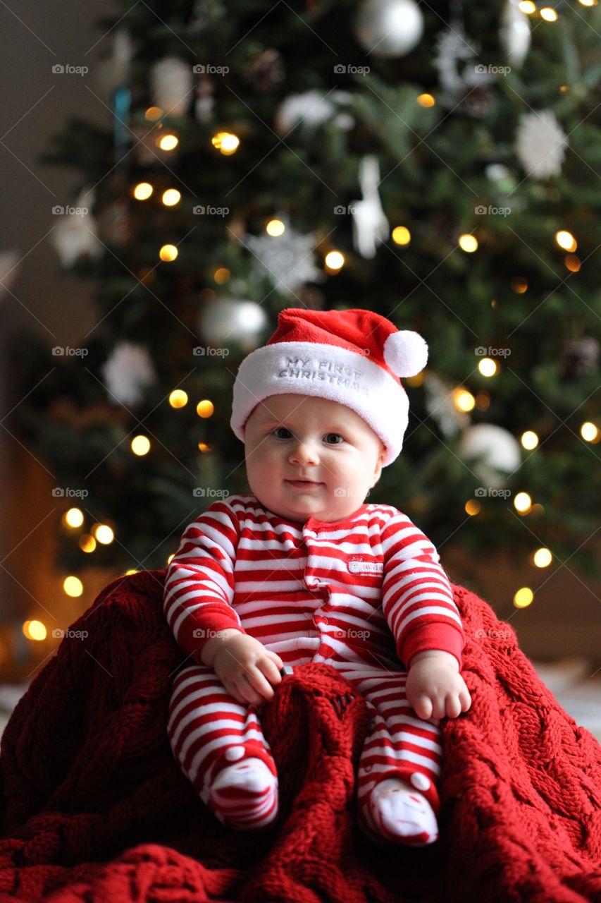 Cute baby sitting near christmas tree