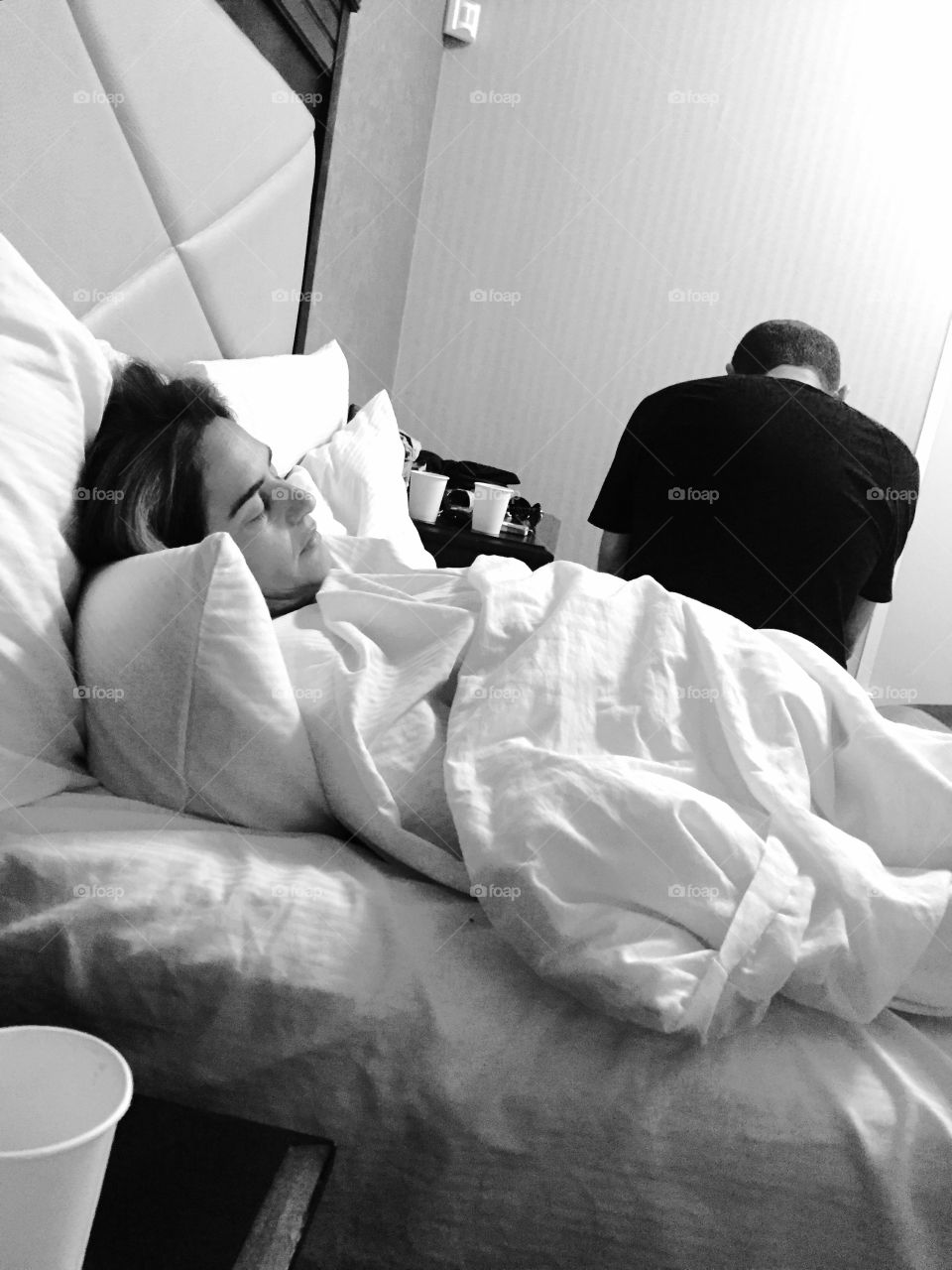 Man sitting and his wife sleeping on bed