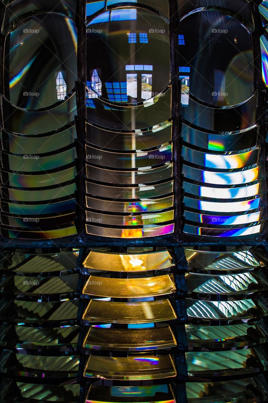 Close up detail of the fresnel lens lighthouse prism at the pigeon point lighthouse in California off the coast of highway one between San Francisco and Santa Cruz, showing the beautiful refractive light of rainbow colors and reflections 