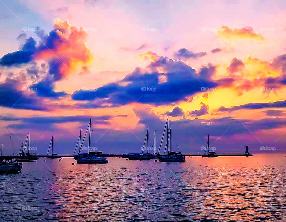 boats in ocean with sunset