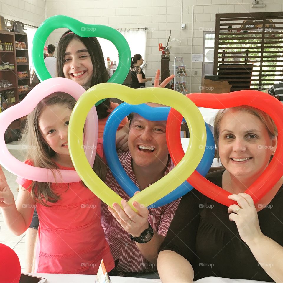 Group of people with heart shape long balloons in front of face