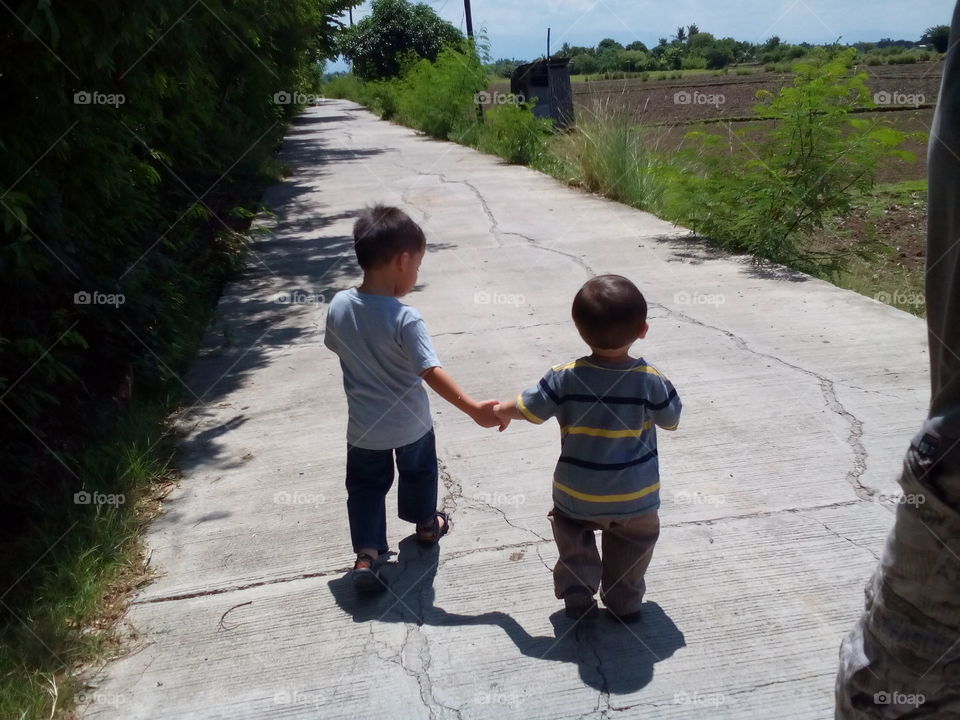 Brothers walk. We have to walk 1km to get a public vehicle to get us to the grocery store. This is their first time to walk holding hands together.