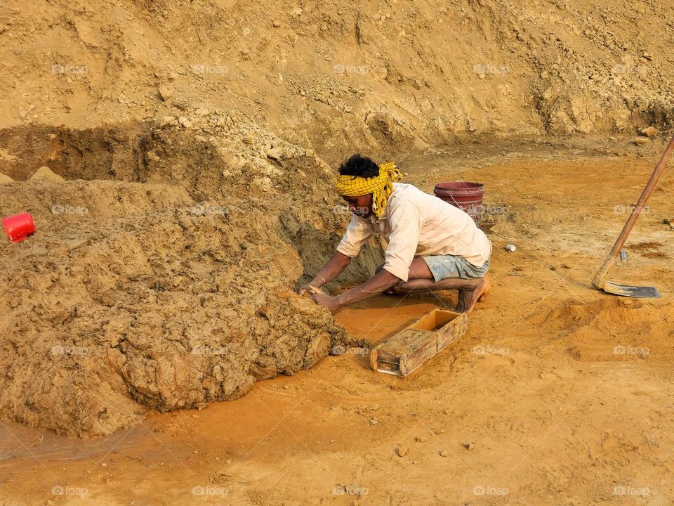 Man making mud mould for making bricks