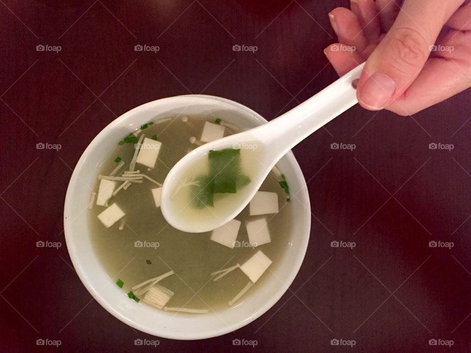 View of person's hand holding plastic spoon