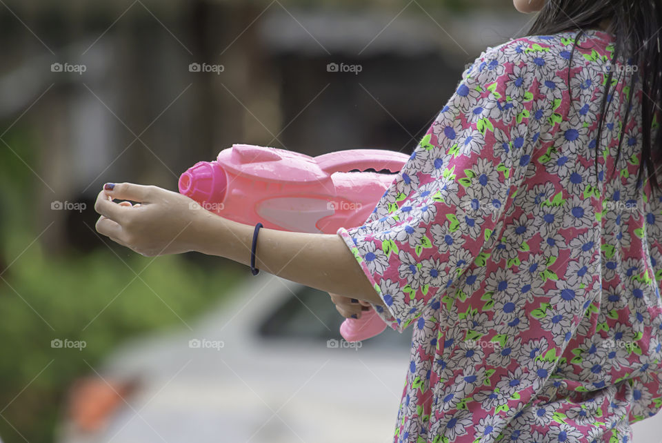 Hand holding a water gun play Songkran festival or Thai new year in Thailand.