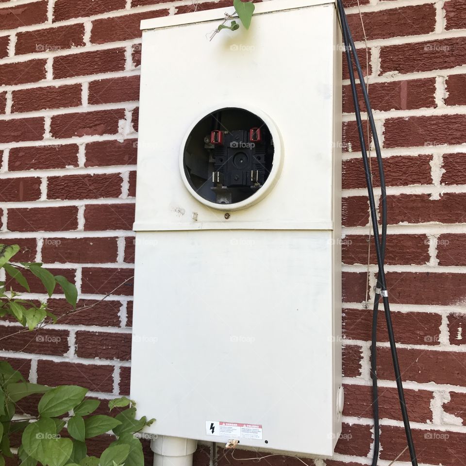 Brick wall with a power box but not an electrical meter