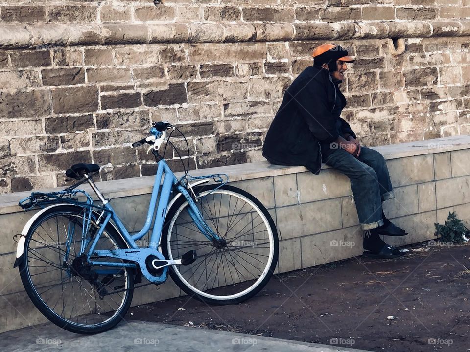 The man sitting near the bicycle 