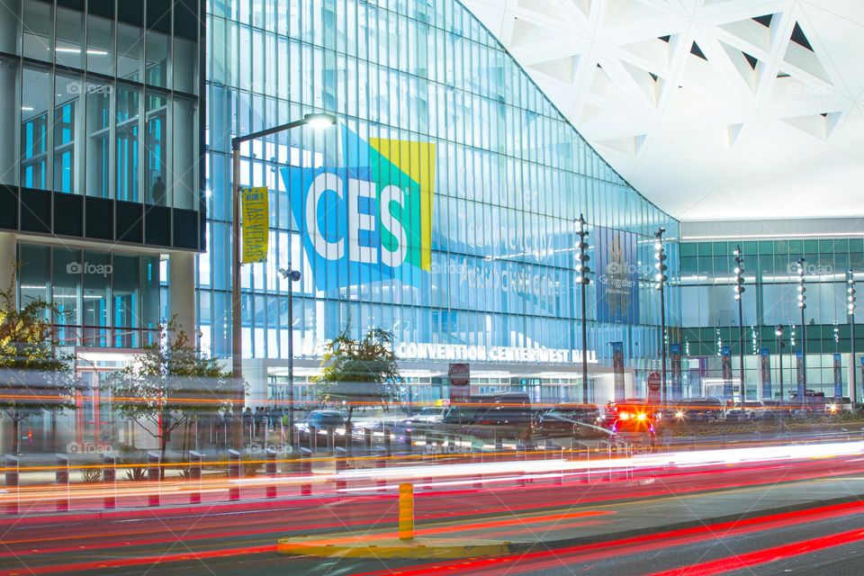 Las Vegas, NV, USA 1-6-2023: Exterior of Convention Center West Hall during CES2023. Logo of CES on glass wall. Light trails from car headlights of traffic passing by. Captured in long exposure.