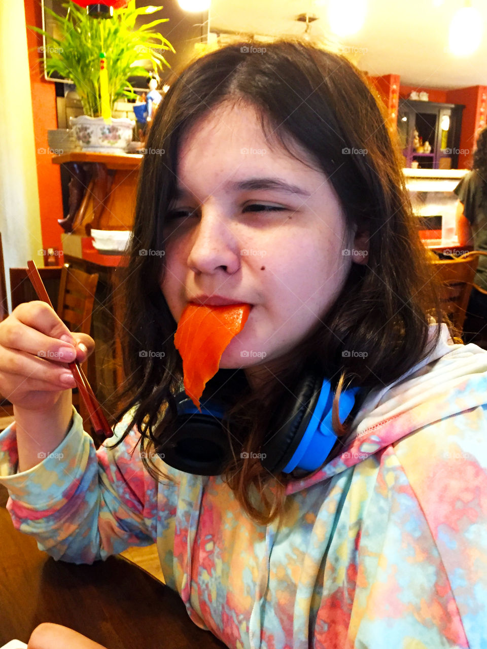 A head shot of my daughter eating her sashimi of salmon. She loves sushi of every kind and was displaying her tongue of salmon pre-gobble! 🍣