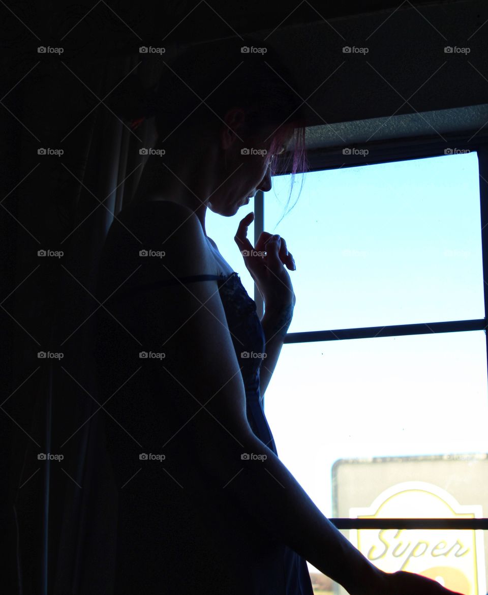 A young woman waits at the window patiently!