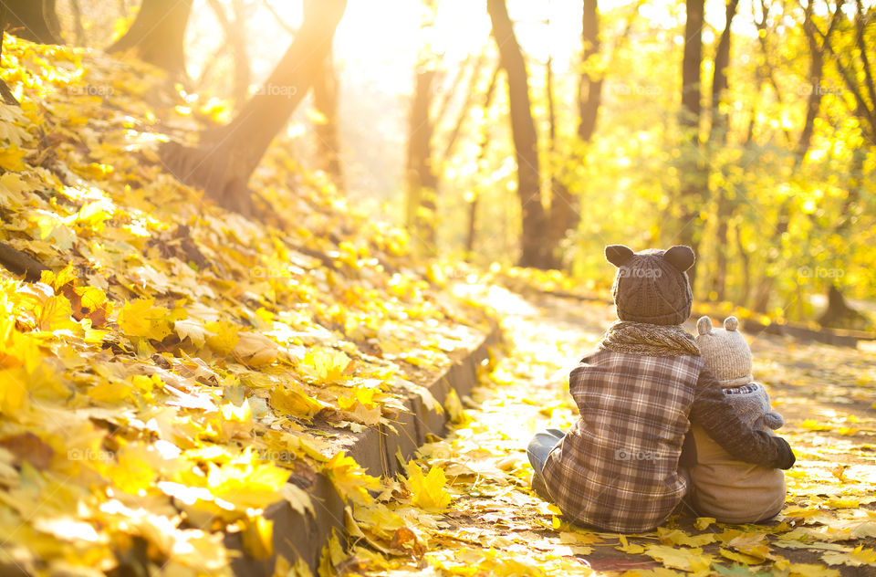 Boys sitting in autumn leaf