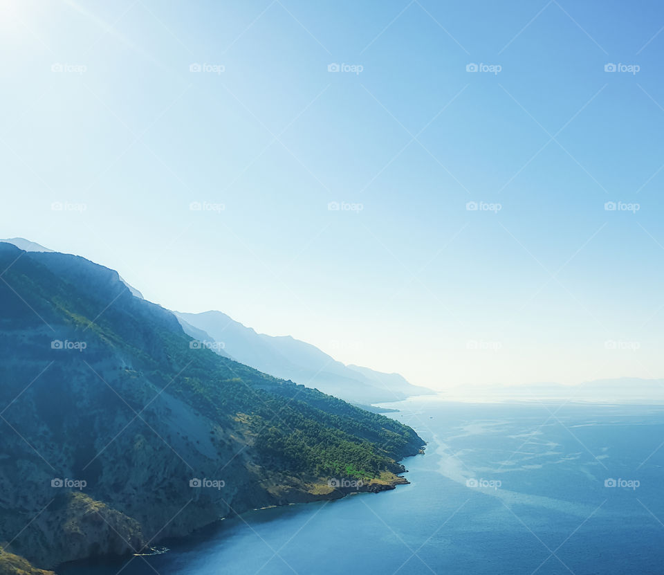 Croatia, Dalmatia, morning summer landscape of the Adriatic coast with mountains, calm sea and clear sky
