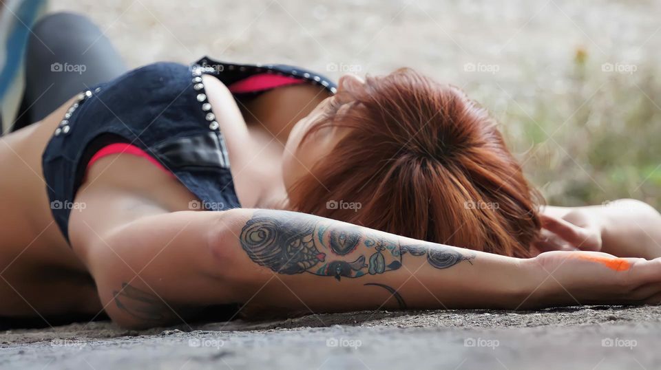 Woman Laying Down
A woman poses with a large wall of graffiti.