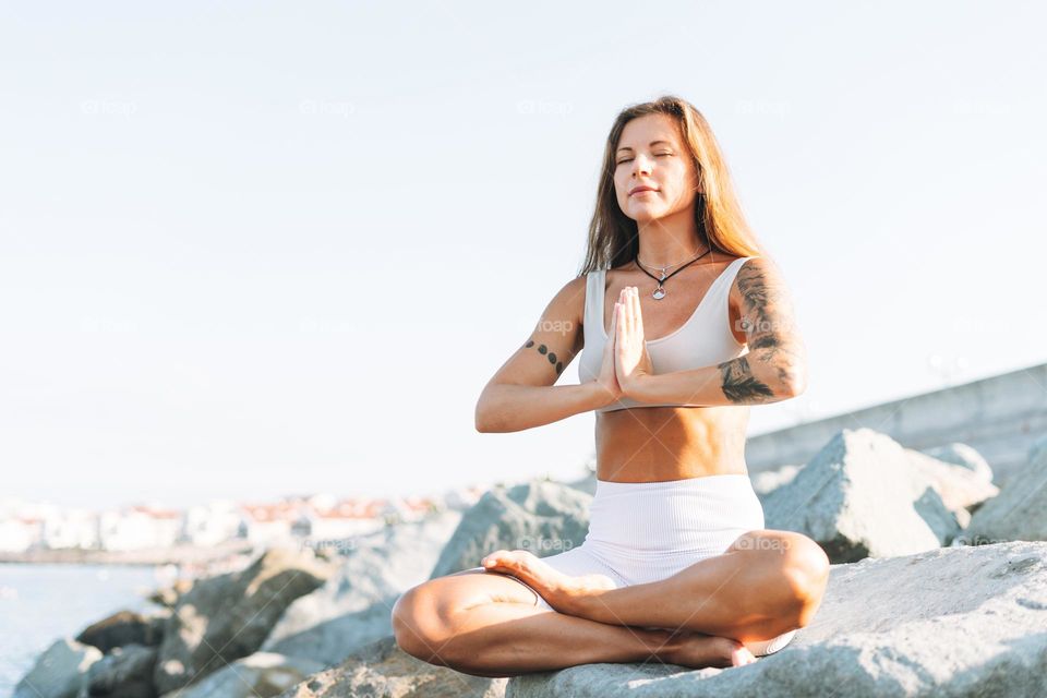 young fit beautiful woman with long hair in white sport clothes practice yoga and enjoy life on the sea beach, mental and phisical health