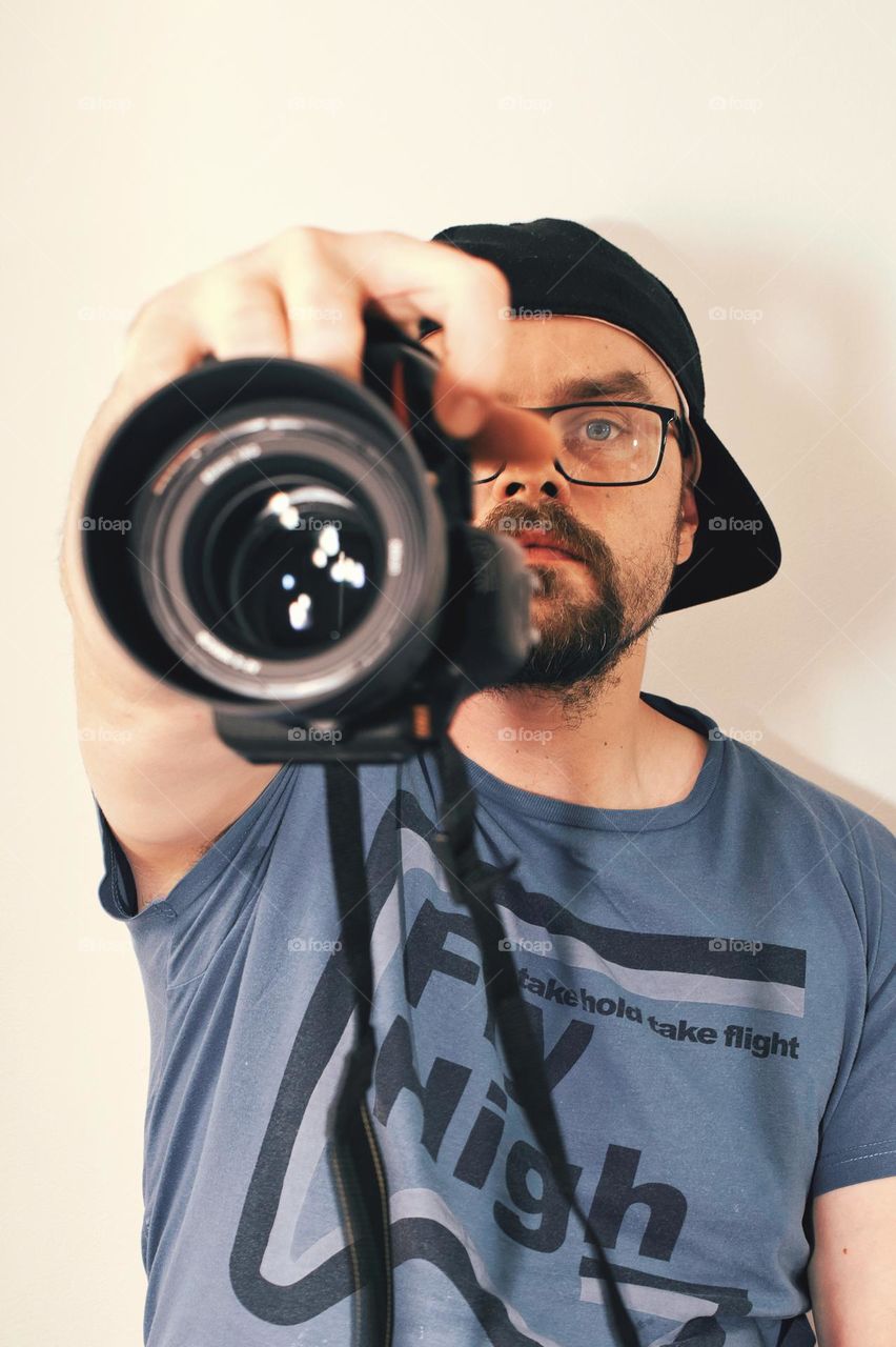 Portrait shot of bearded man with glasses holding camera