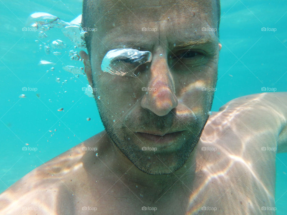 underwater portrait. underwater male portrait with water bubble on his eye