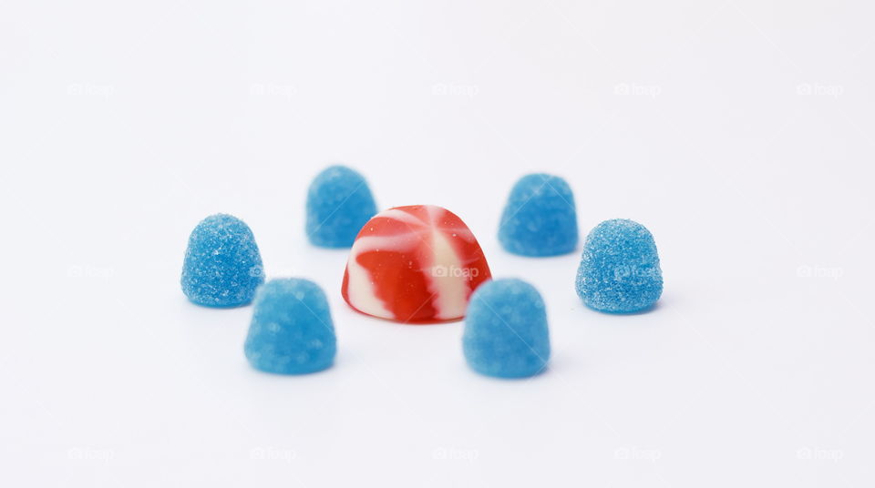 Blue sweets surrounding a bigger red sweet