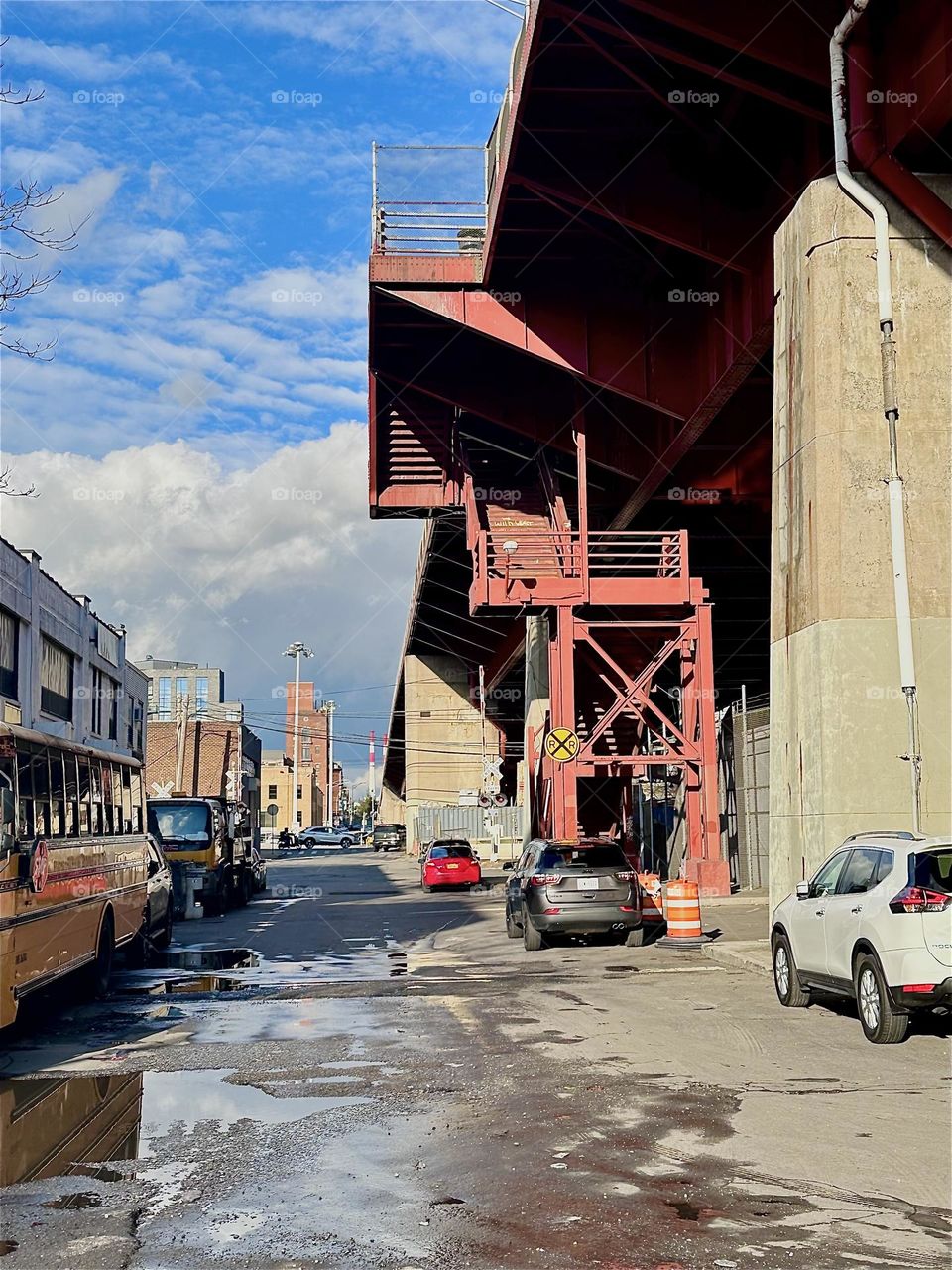 This is the red metal staircase of the “Pulaski Bridge” at “Newtown Creek” in LIC, Queens seen from the parking lot by “11th St” and “Borden Ave” beneath it. The cubist and expressionistic structures are quite intriguing. 2023. Hypnotic Productions