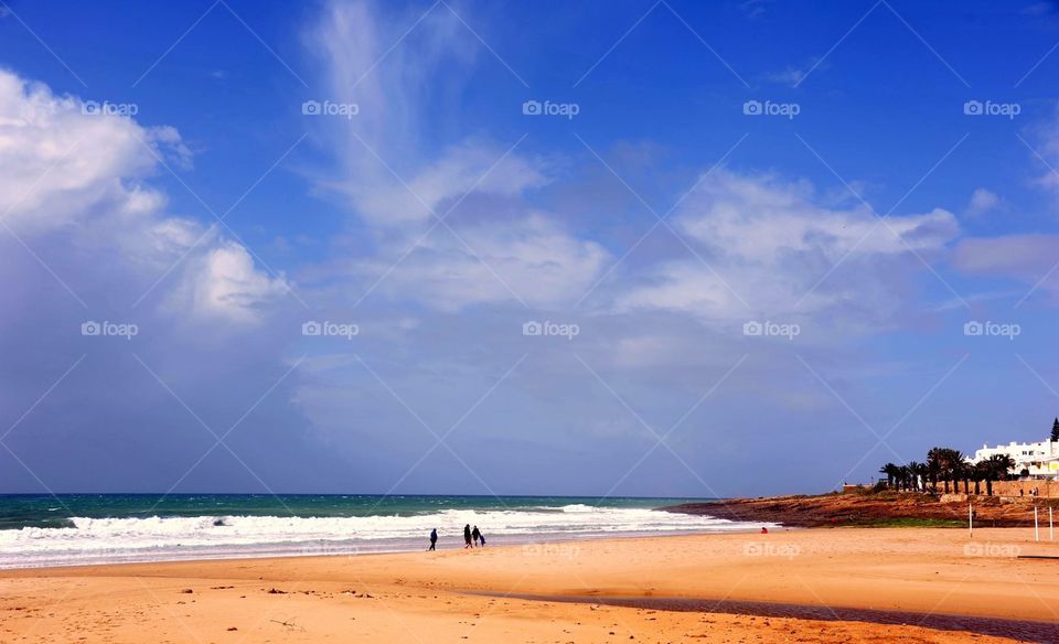 A few people on a Beach on a windy and cold day