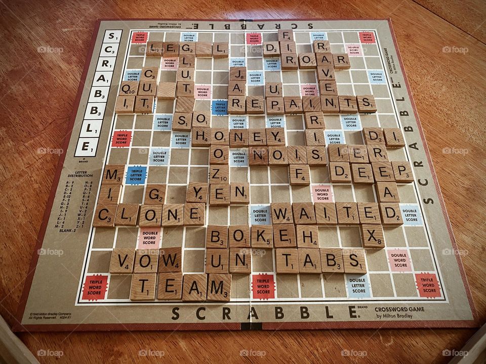 Scrabbles tiles made of wood. Lay flat on the brown table. 