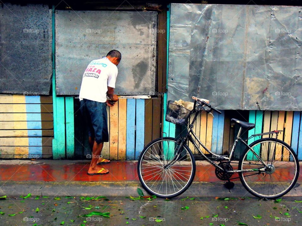 man, bicycle and a store