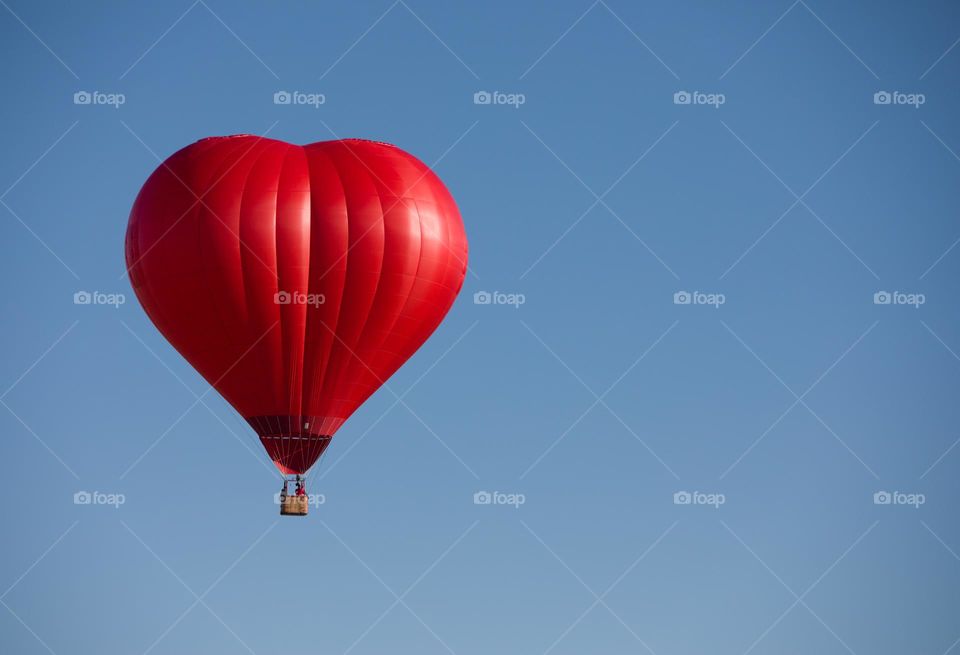 Red Heart Hot Air Balloon against a Beautiful Blue Sky background