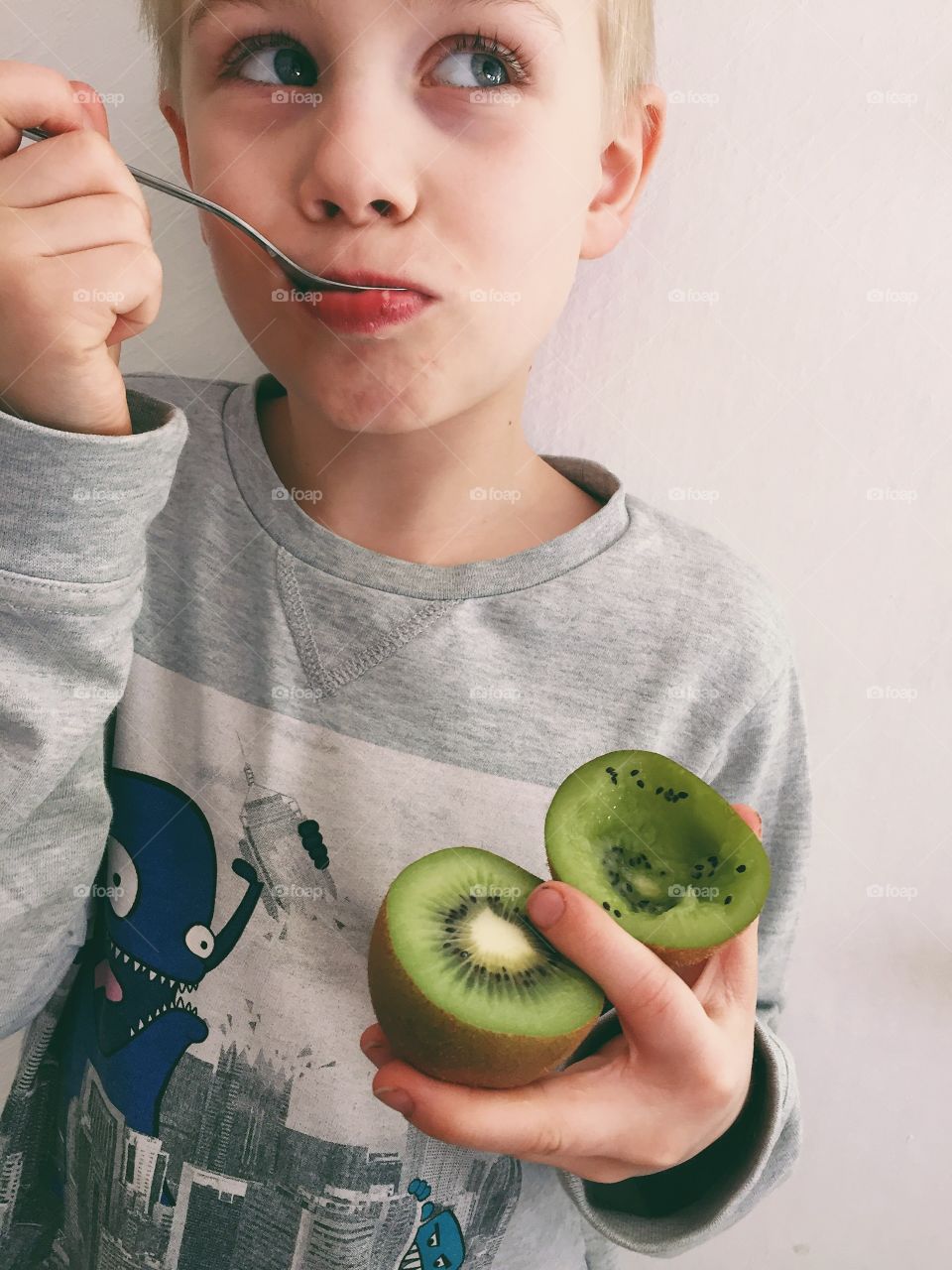 Boy eating kiwi