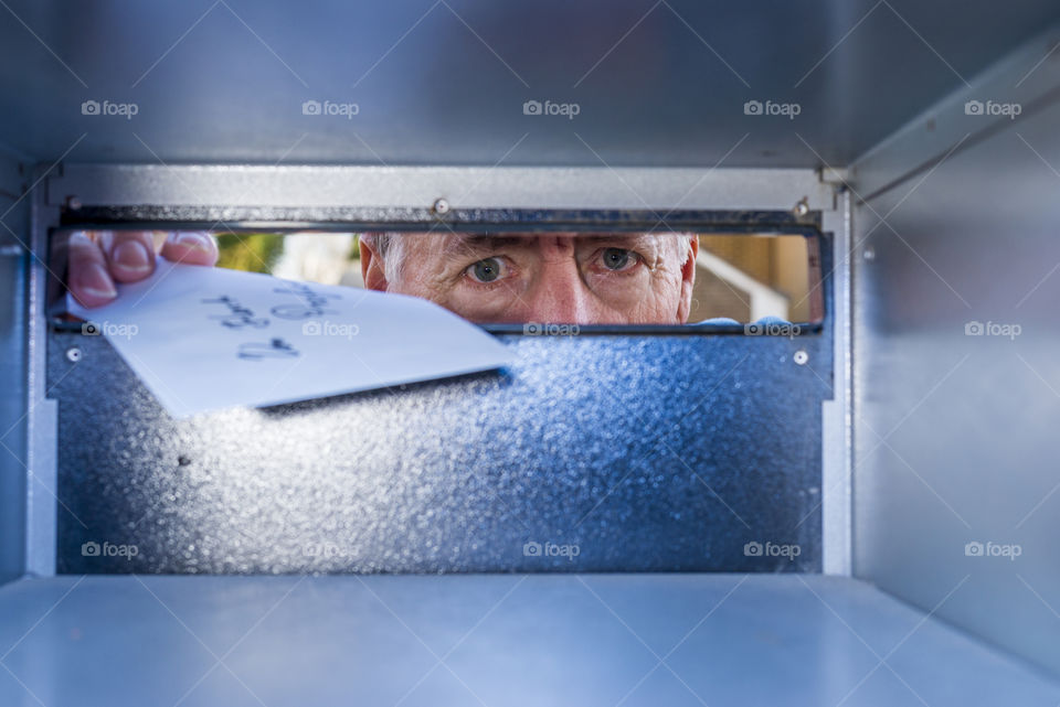 inside view of a mailbox, with a man delivering mail