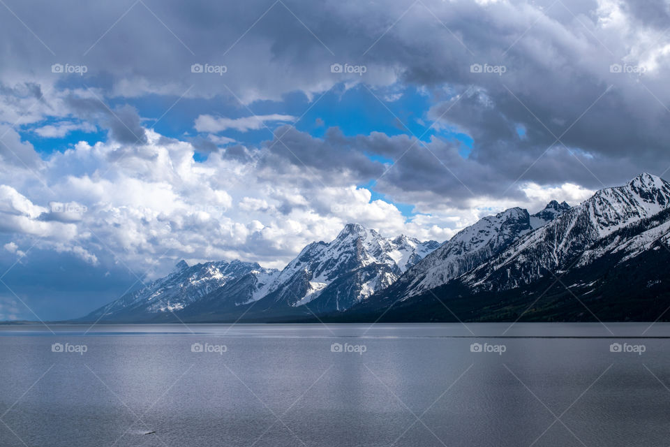 Snow-capped mountains with thick clouds hovering 