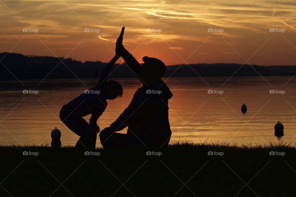 Silhouette of two people at lake