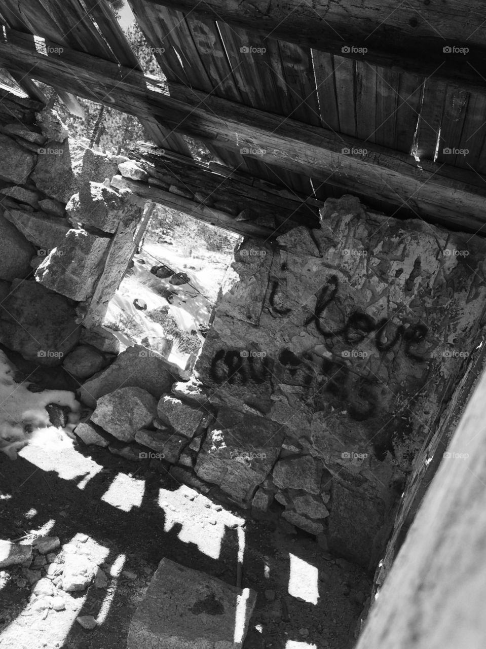 Happiness can be found in the darkest of times. Black and white photo of the inside of a old burned down house in Big Bear with graffiti on the walls