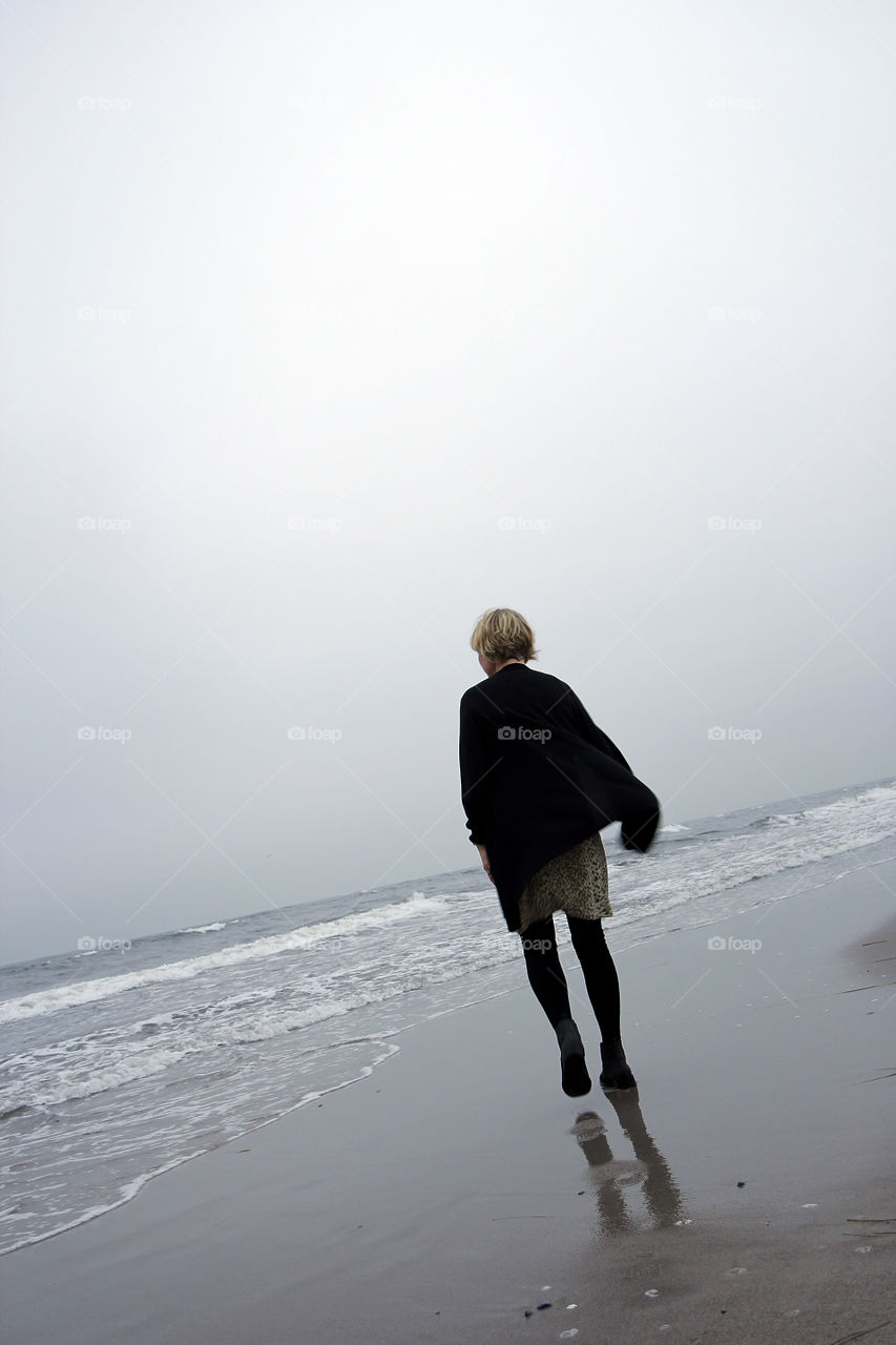 Woman walking alone on the beach