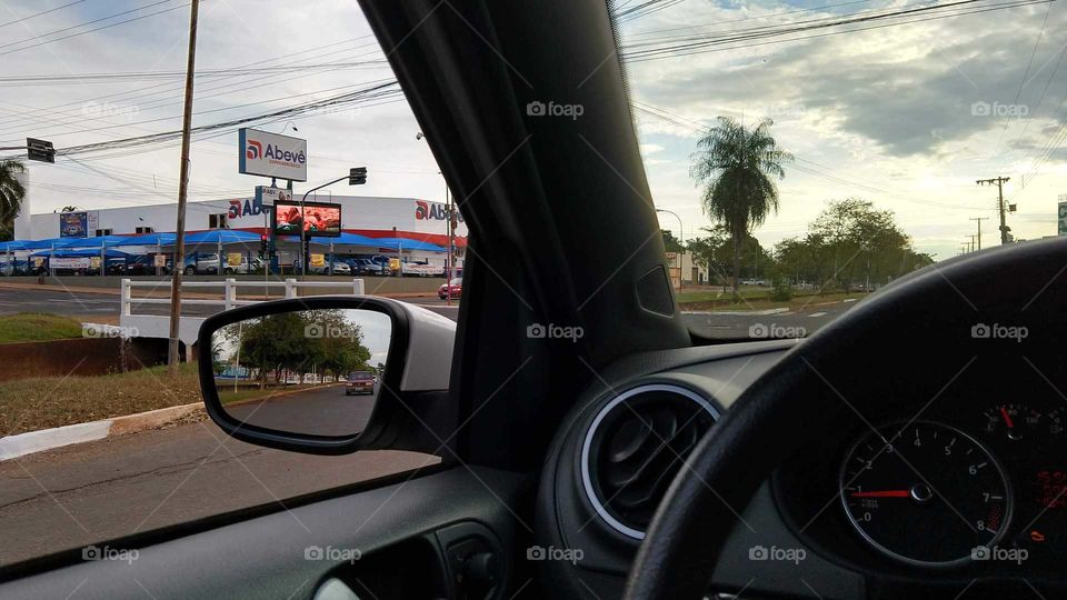 Do interior do carro, rua, comercio.