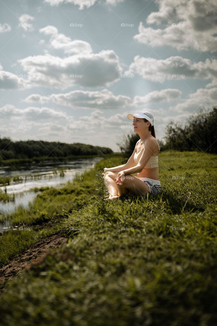 girl resting meditation on the river bank