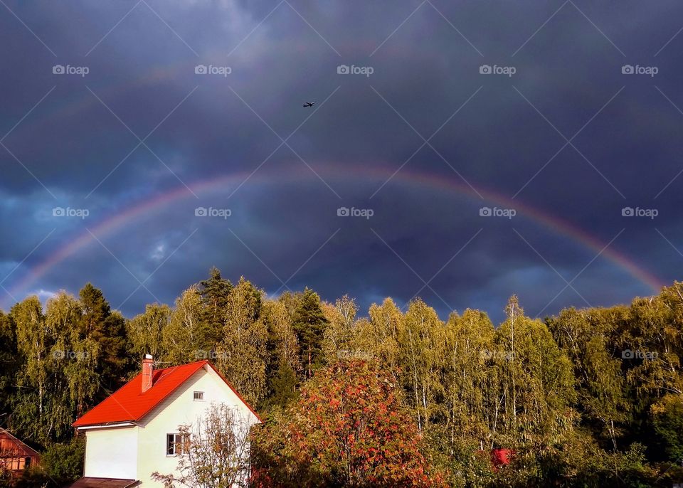 Rainbow over the house and forest 