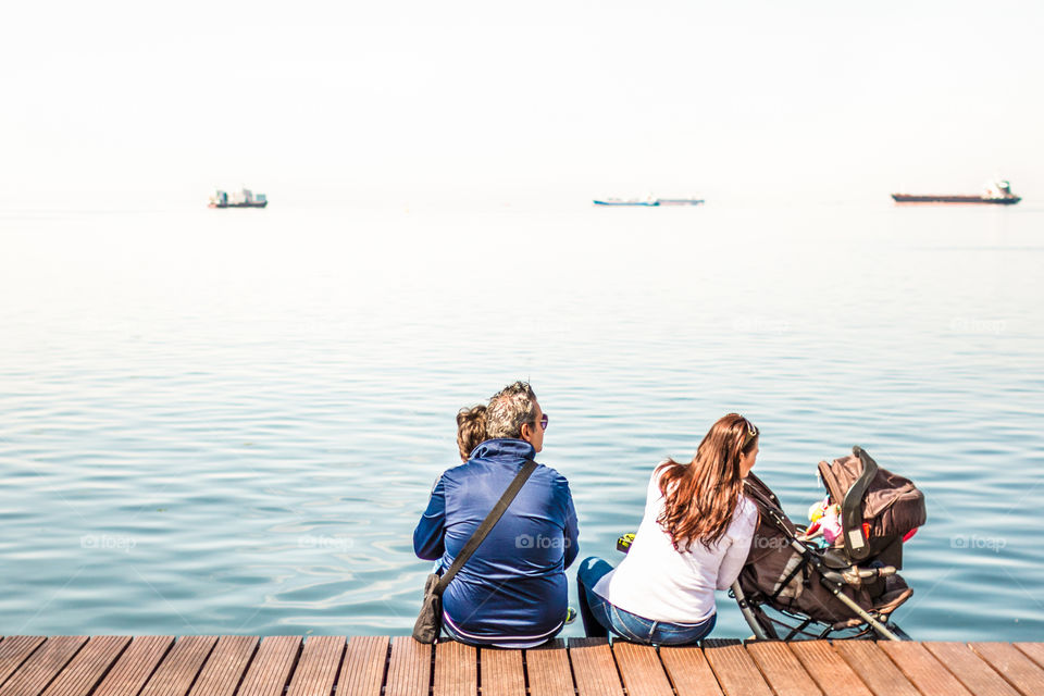 Family Enjoying The View Sitting On The Dock
