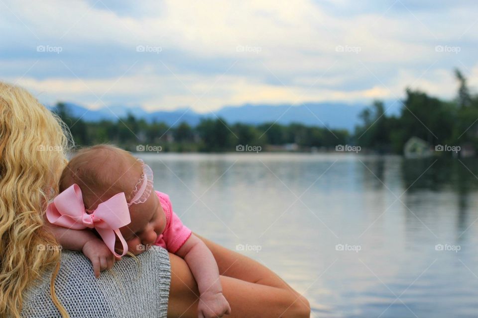 Mother holding an Infant overlooking a lake