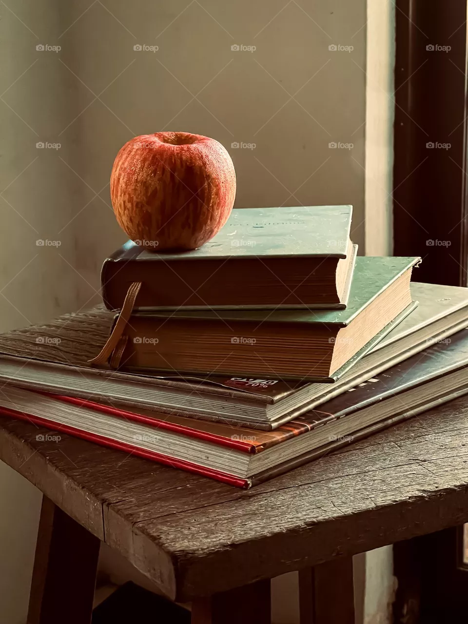 An apple on top of stacks book symbolises teacher and education