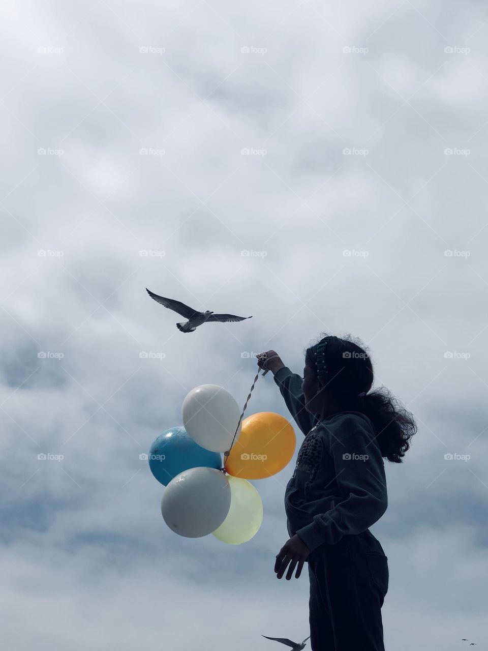 Beautiful girl holding multicolour balloons 