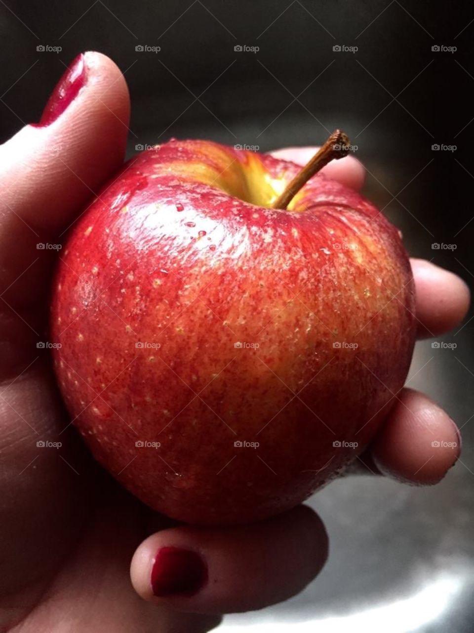 Close-up of human's hand holding apple