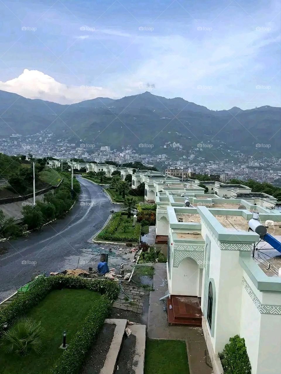 The image embodies a natural natural plate of the mountains of nature, where green agricultural stands are graded on the slopes as if they were lines of a poem, which fog harmoniously wrapped, and clouds hugged them in the mountain knife and the whis