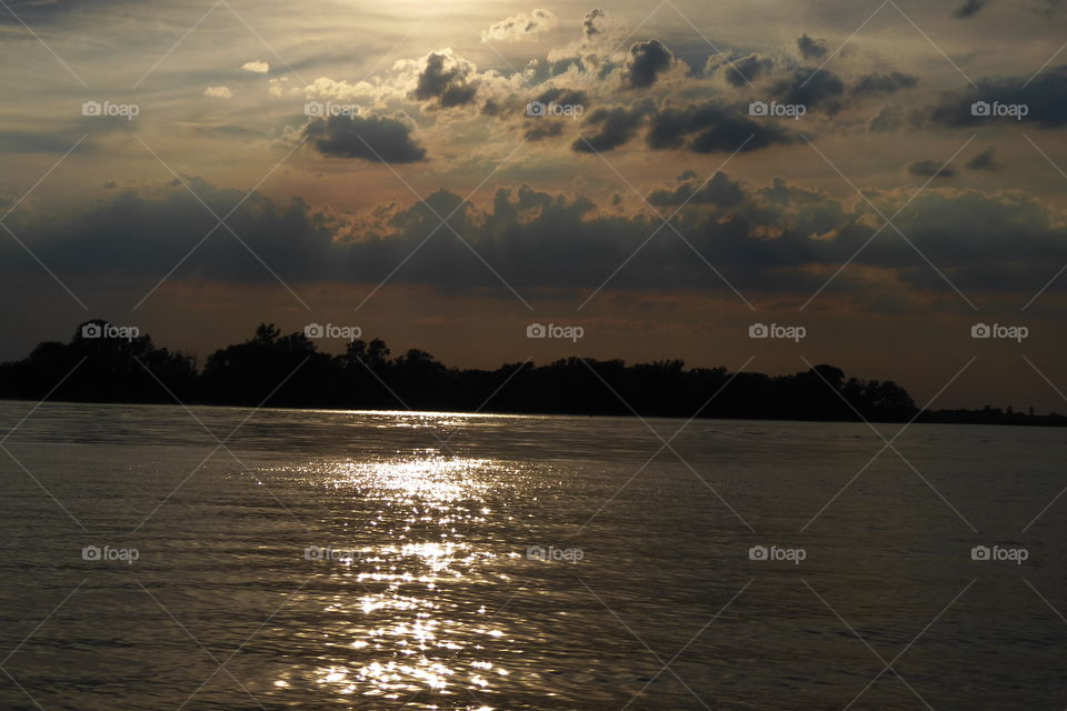 Evening sunlight on water and cloudy sky
