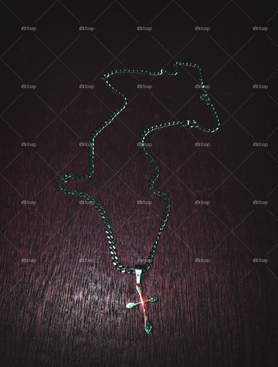 A cross necklace in the dark red place.