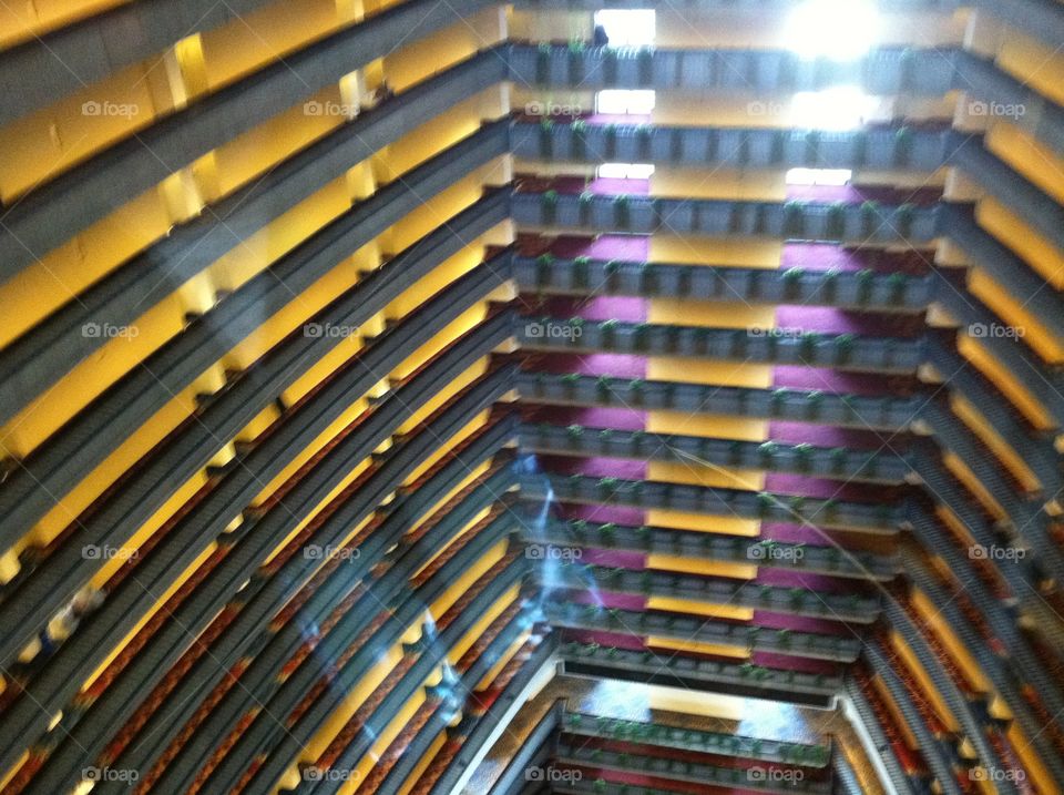 View of atrium of huge city hotel from glass elevator.