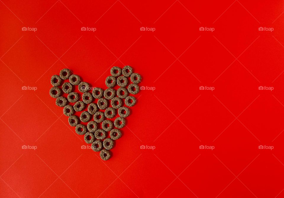 heart of round snacks on a bright magenta background