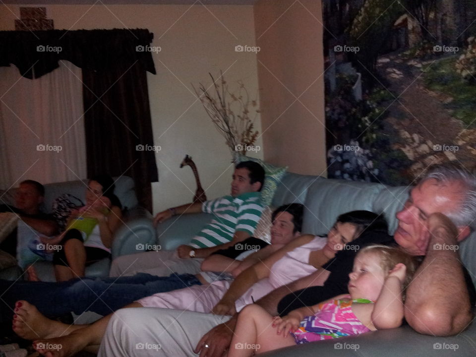 Family resting on sofa